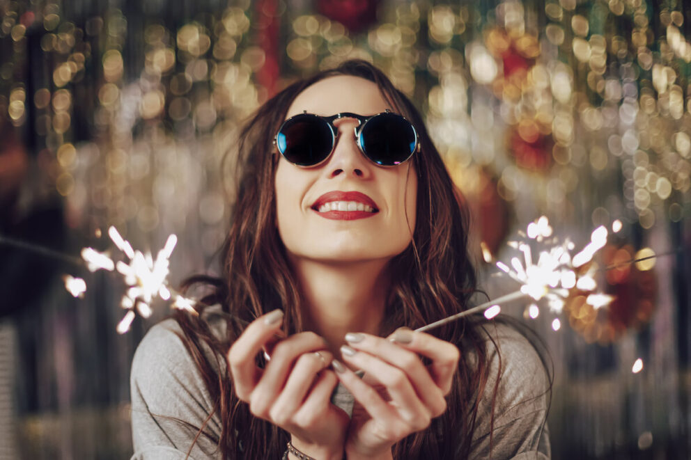 Beautiful girl holding sparklers in hands