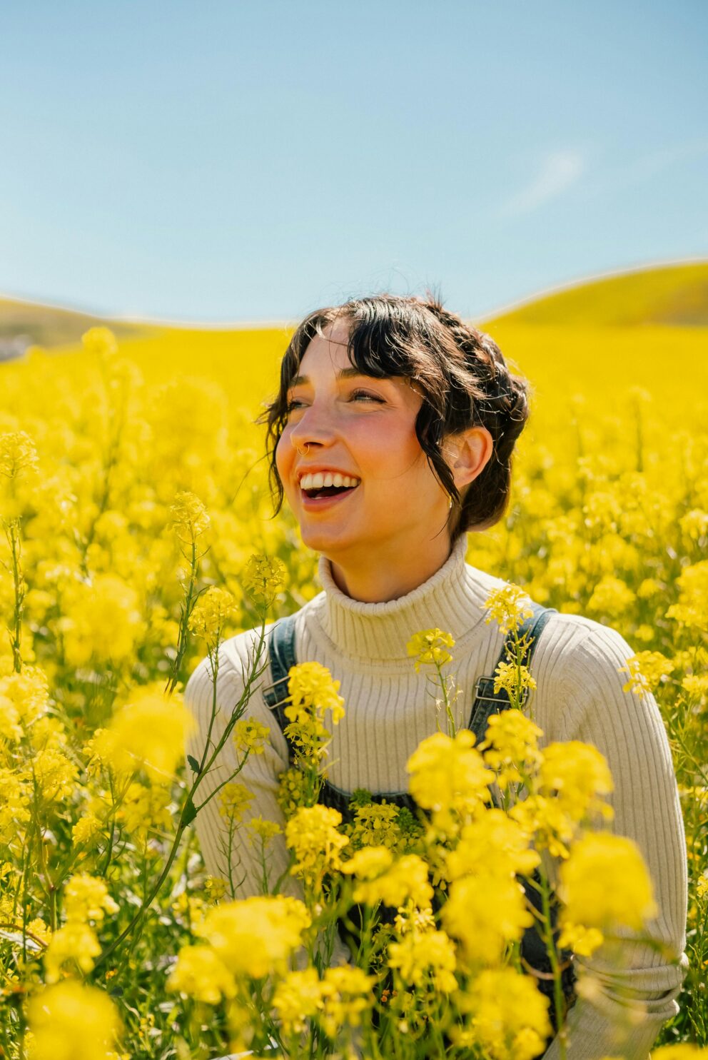 woman protecting lips with SPF in a field of yellow flowers after visiting dentist South Brooklyn, NY for an oral cancer screening